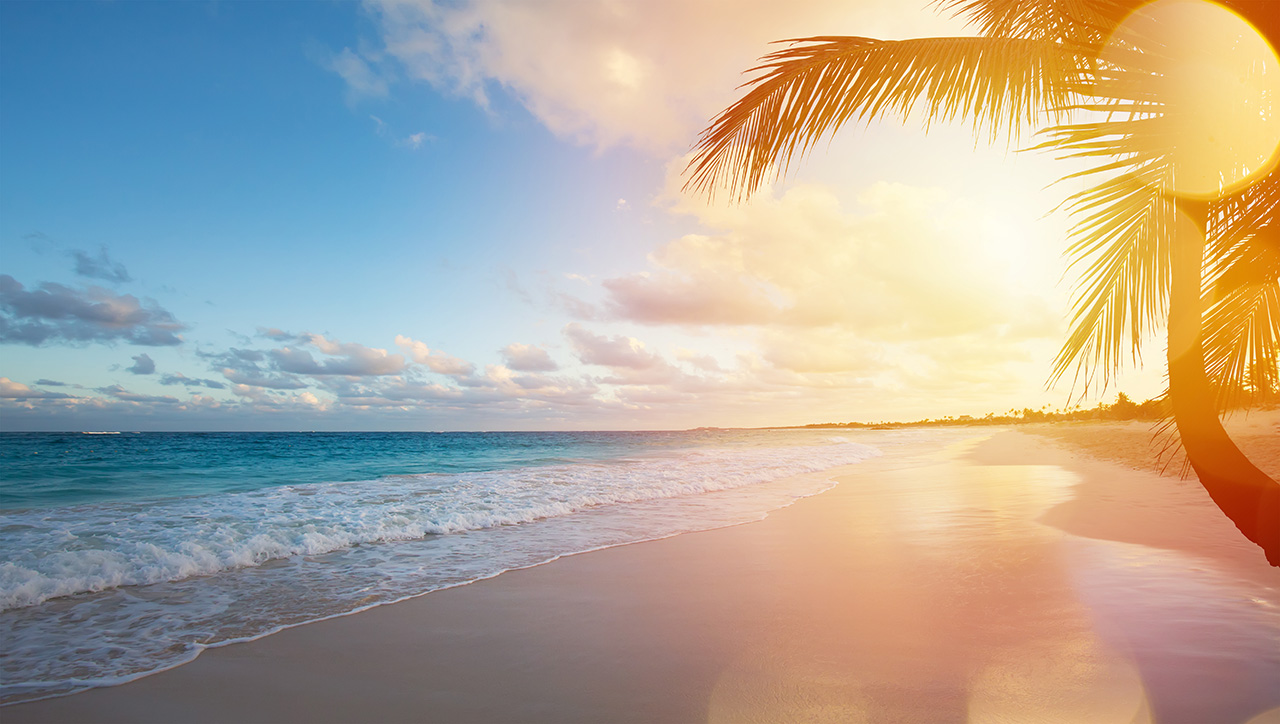 Ocean at sunset with an empty tropical beach