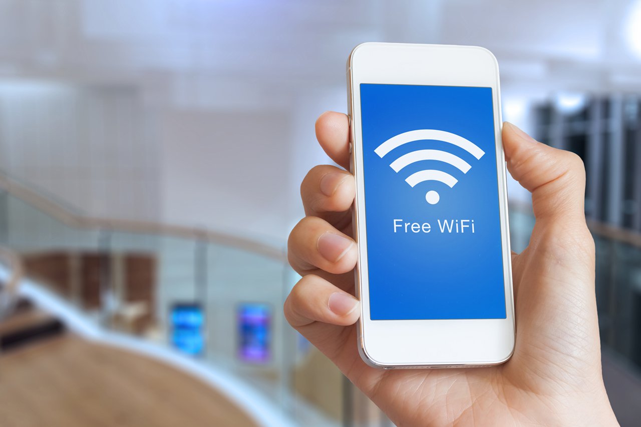 closeup hand holding smartphone with free wifi hotspot on screen