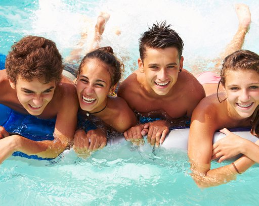 group of teenage friends having fun in swimming pool